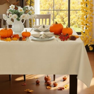 Table decorated with pumpkins, flowers, and autumn leaves.