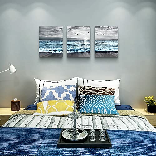 Bedroom with ocean-themed wall art and decorative pillows.