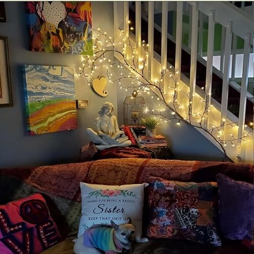 Cozy living room with art, pillows, and string lights on staircase.