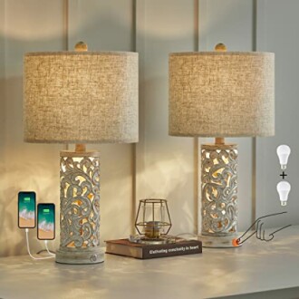 Two decorative table lamps with intricate design, USB ports, bulbs, and a charging phone.