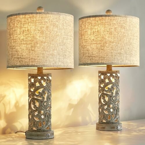 Two decorative table lamps with intricate bases and fabric shades.