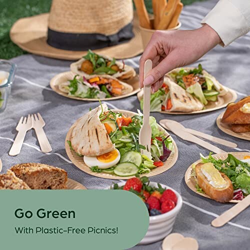 Plastic-free picnic with salads, bread, and berries on a blanket.