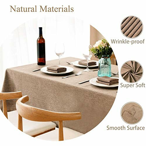 Dining table with brown tablecloth, wine bottle, glasses, plates, and flowers.