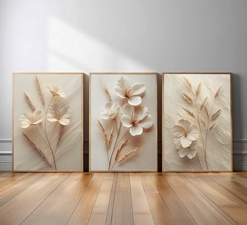 Three minimalist floral art panels on a wooden floor.