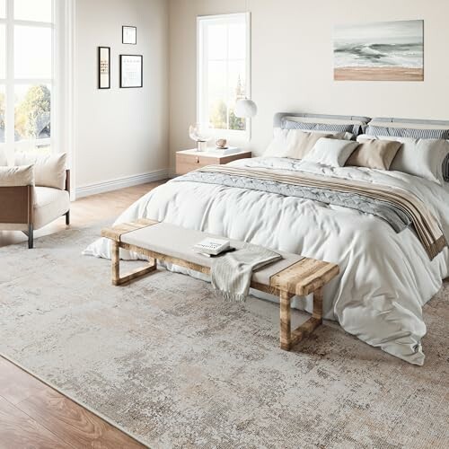 Modern bedroom with bed, armchair, and artwork on walls.