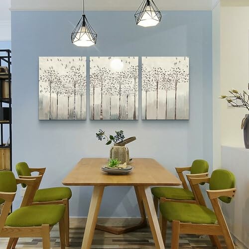 Dining room with green chairs, wooden table, and tree-themed wall art.