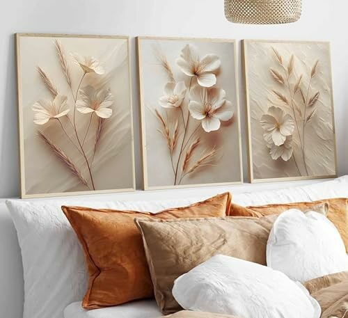 Neutral floral wall art above bed with orange and white pillows.