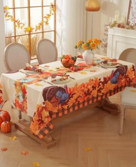 Festive Thanksgiving table setting with autumn-themed tablecloth and decorations.