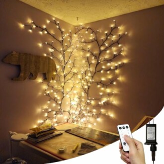 Corner of a room decorated with tree-shaped fairy lights and wooden bear wall art.