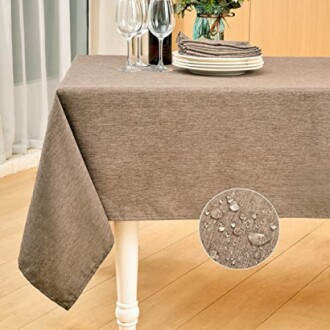 Brown waterproof tablecloth on dining table with plates and wine glasses.