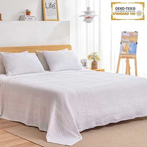 Modern bedroom with white bedding and decor.