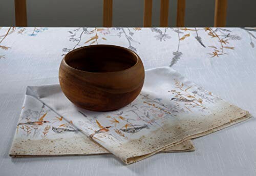 Wooden bowl on a floral tablecloth with napkin.